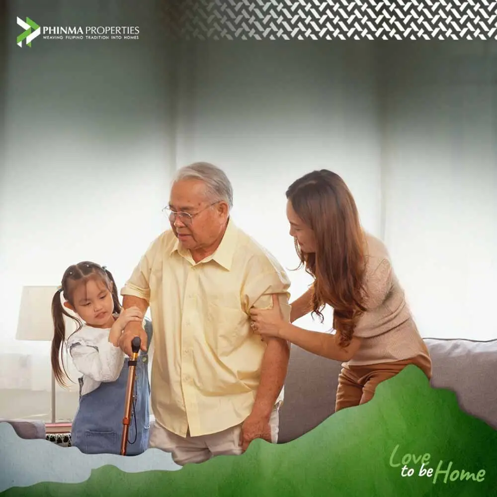 A child and her mother helping an old man walk.