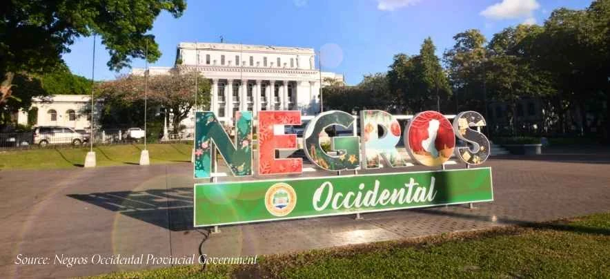 Iconic Negros Occidental Provincial Capitol building and decorative Negros Occidental sign at the green Capitol Lagoon Park.