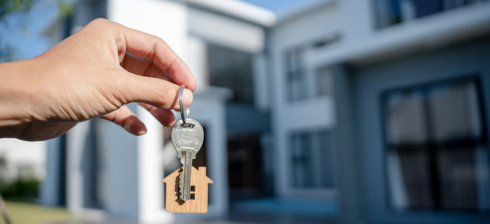 A person holding a key to their new property, illustrating the successful first steps in buying a lot in the Philippines.