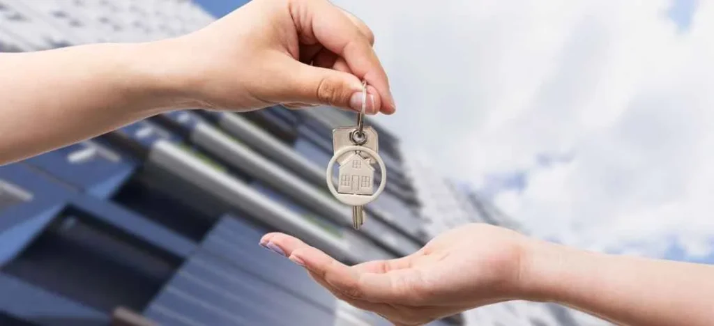 New owner receiving keys to a Metrotowne unit, a key step in how to buy a move-in ready condo for rental income.