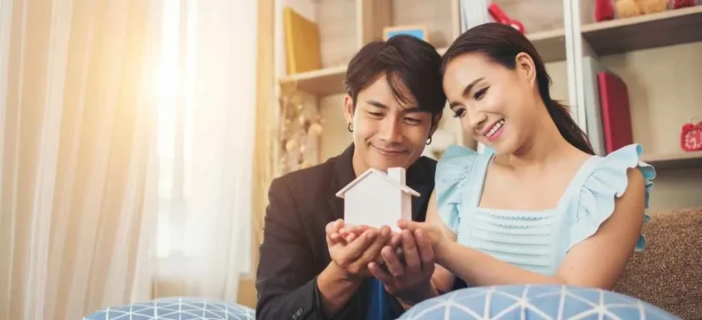 Smiling partners with a small house icon, discussing low entry cost property appreciation potential in Las Piñas.